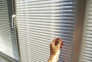 Person Closing the Blinds