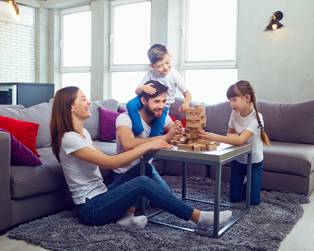 Family playing jenga on a table in the living room